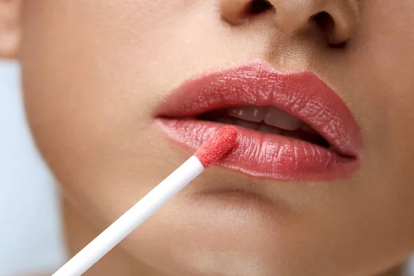 Maquillaje de belleza. Hermosa mujer aplica brillo labial — Foto de Stock