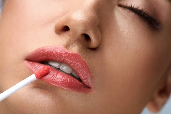 Beauty Make-up. schöne Frau trägt Lipgloss auf — Stockfoto