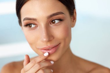 Güzellik yüz. Güzel kadın dudaklar Dudak kremi ile dokunmak