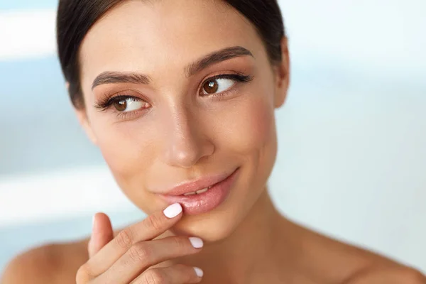 Beauty Face. Hermosa mujer tocando labios con bálsamo en los labios — Foto de Stock