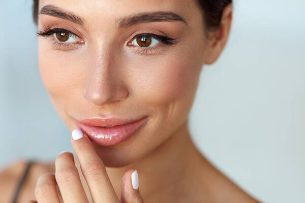 Beauty Face. Beautiful Woman Touching Lips With Lip Balm On