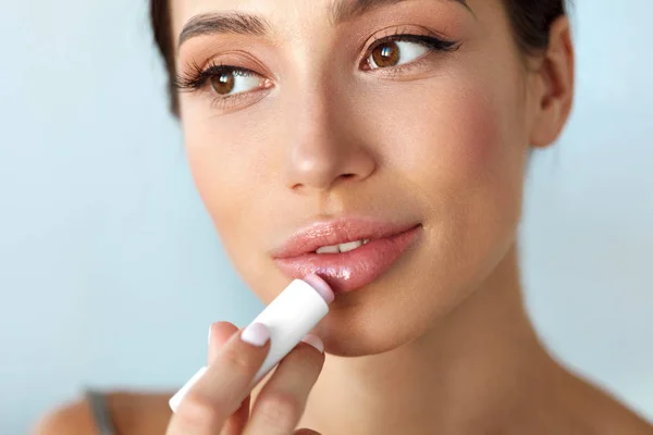 Schöne Frau mit Schönheit Gesicht trägt Balsam auf die Lippen auf. Hautpflege — Stockfoto