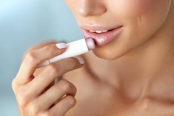 Hermosa mujer que aplica protector labial en la piel de los labios. Belleza — Foto de Stock