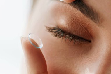 Eyelens üstünde parmak ile kapalı kadın göz closeup
