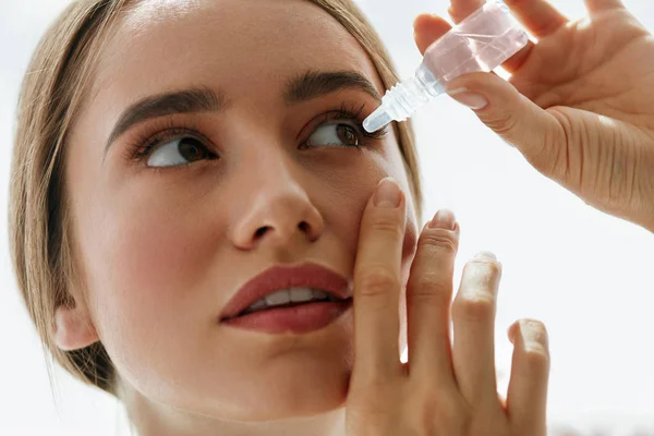 Mujer hermosa joven con gotas para los ojos. Concepto de visión y medicina — Foto de Stock