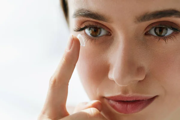 Nahaufnahme einer schönen Frau, die Augenlinse in Auge aufträgt — Stockfoto