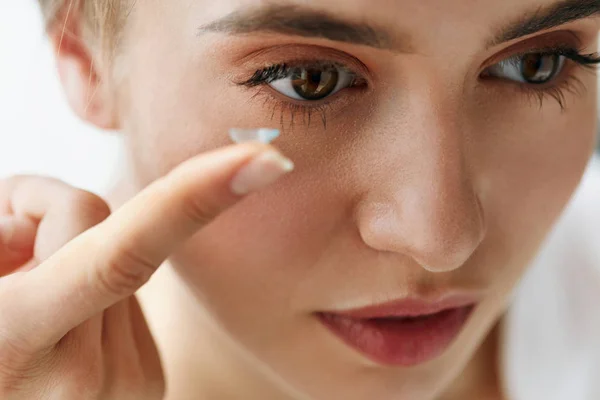 Primer plano de la hermosa mujer aplicando lente ocular en el ojo —  Fotos de Stock