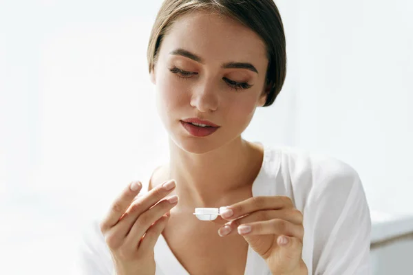 Augen und Gesundheit. schöne Frau mit Augenlinse und Linsenbox — Stockfoto