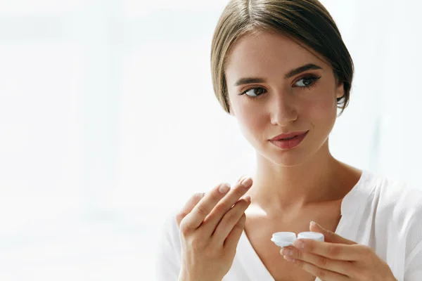 Augen und Gesundheit. schöne Frau mit Augenlinse und Linsenbox — Stockfoto