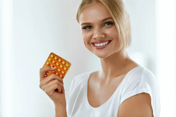 Красивая женщина держит противозачаточные таблетки, пероральные контрацептивы — стоковое фото