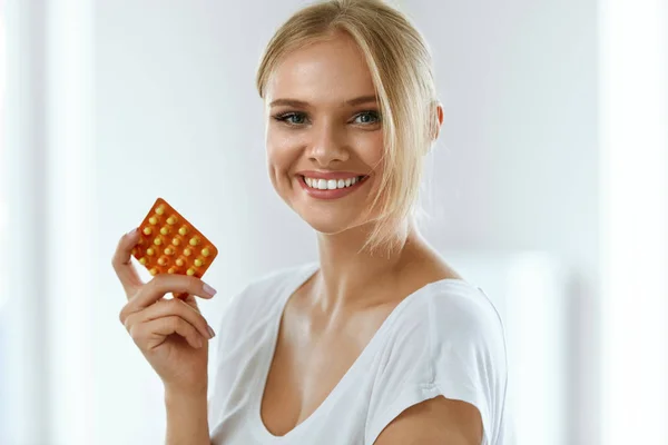Hermosa mujer sosteniendo píldoras anticonceptivas, anticonceptivo oral —  Fotos de Stock