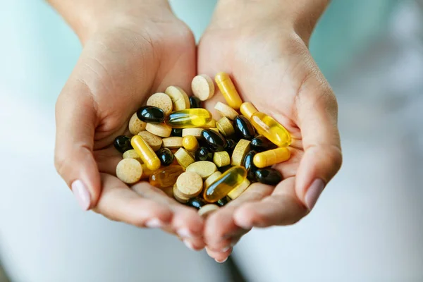 Vitaminas e suplementos. Mulher mãos cheias de pílulas de medicação — Fotografia de Stock