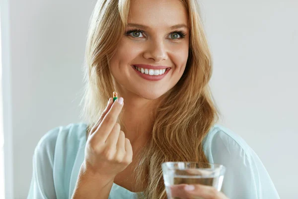 Hermosa mujer sonriente tomando la píldora de vitamina. Suplemento dietético —  Fotos de Stock