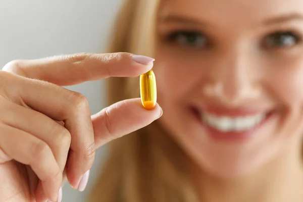 Schöne Frau mit Fischöl-Pille in der Hand. gesunde Ernährung — Stockfoto