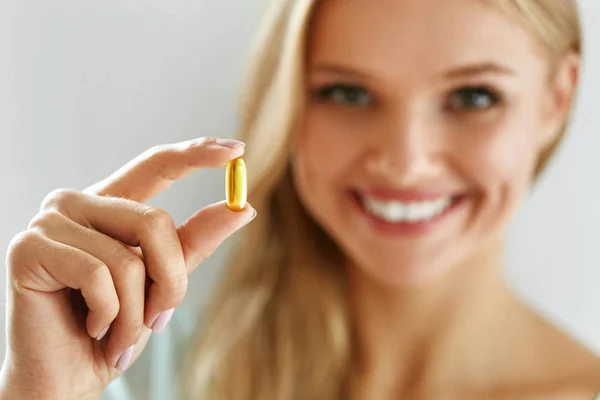 Vitamin ve ek. Balık yağı kapsül tutan güzel kadın — Stok fotoğraf