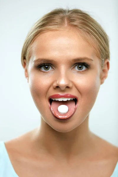 Bella donna sorridente che prende la medicina, tenendo pillola sulla lingua — Foto Stock