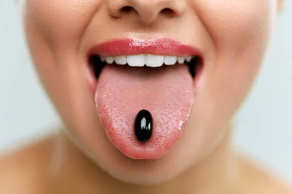 Hermosa boca de mujer con píldora en lengua. Chica tomando medicina — Foto de Stock