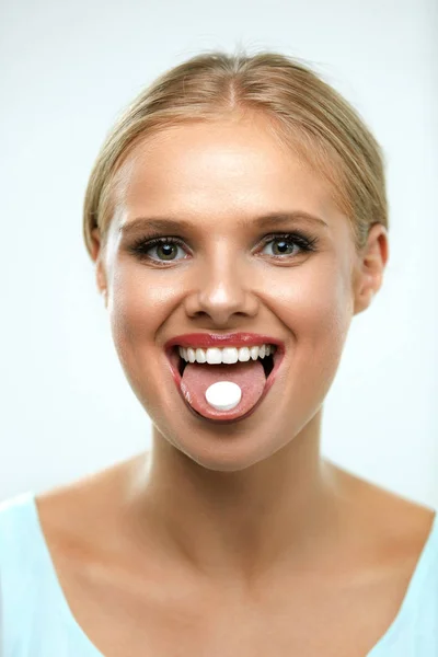 Beautiful Smiling Woman Taking Medicine, Holding Pill On Tongue Royalty Free Stock Images