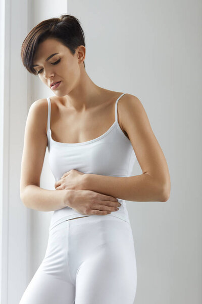 Женское здоровье. Красивая женщина чувствует боль в животе
