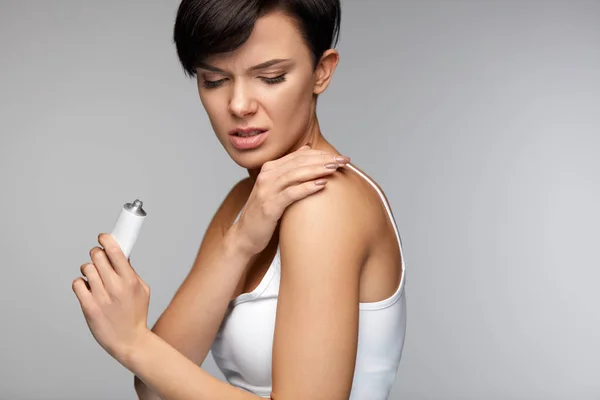 Tratamiento de lesiones. Hermosa mujer sintiendo dolor, aplicando crema — Foto de Stock