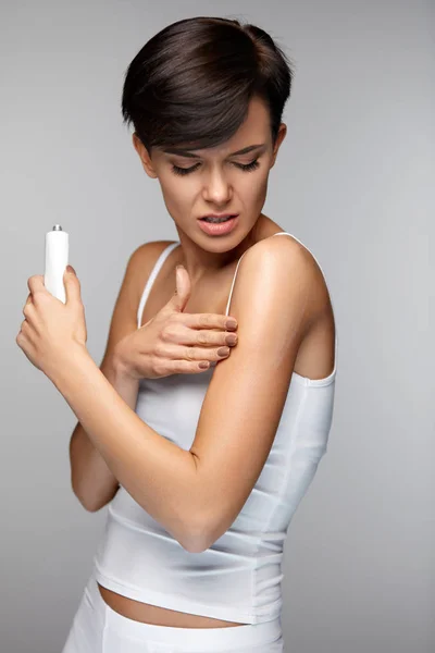 Dor no corpo. Mulher bonita sentindo dor nos braços, aplicando creme — Fotografia de Stock