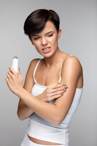 Dolor corporal. Hermosa mujer sintiendo dolor en los brazos, aplicación de crema — Foto de Stock