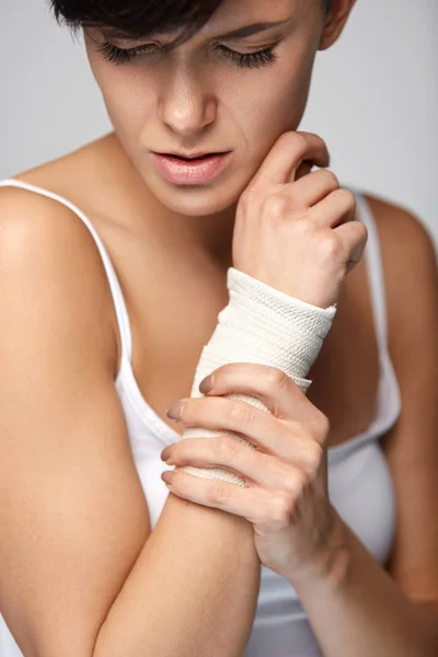 Lesão nas mãos. Mulher bonita com bandagem na mão sentindo dor — Fotografia de Stock