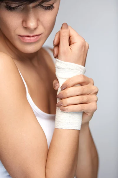 Kontuzja ręki. Piękna kobieta z opaska na rękę uczucie bólu — Zdjęcie stockowe