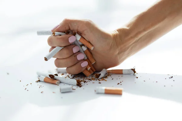 Closeup de mão feminina segurando cigarros. Pare de fumar. — Fotografia de Stock