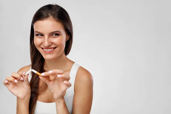 Proibido fumar. Fechar de mulher bonita com cigarro quebrado — Fotografia de Stock