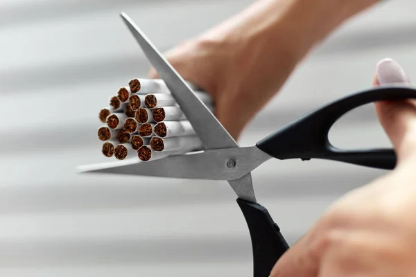 Smettila di fumare. Primo piano di donna mani taglio sigarette — Foto Stock
