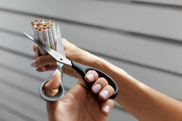 Deja de fumar. Primer plano de las manos de la mujer cortando cigarrillos — Foto de Stock