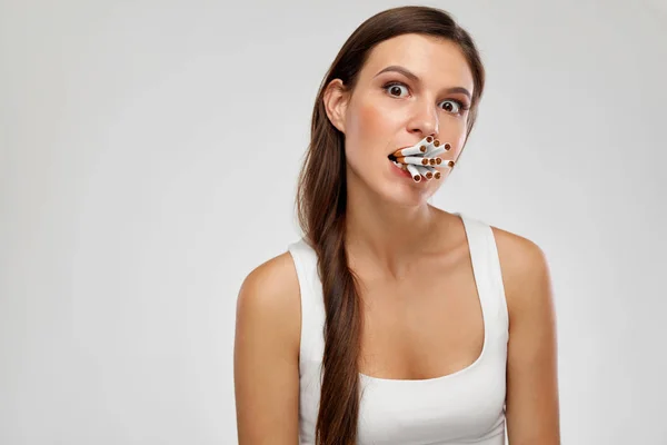 Schlechte Angewohnheit. junge Frau mit Bündel Zigaretten im Mund — Stockfoto
