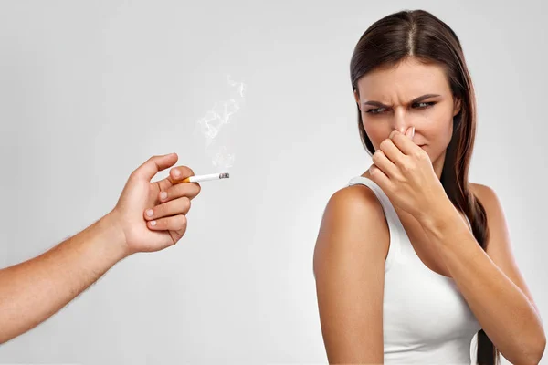 Fumar. Mujer hermosa sosteniendo la nariz, oliendo olor a cigarrillo — Foto de Stock