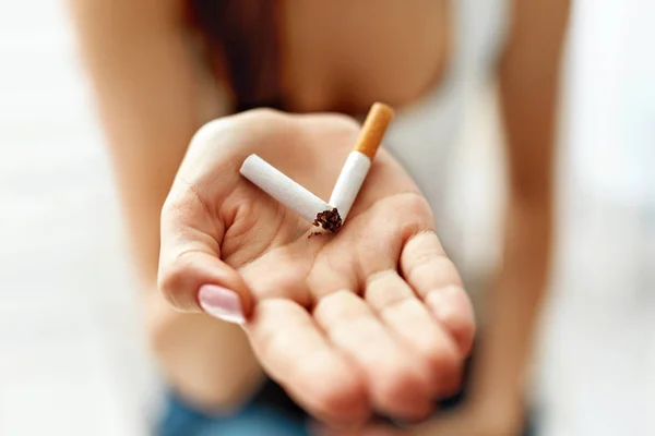 女人的手显示折断了的香烟。不健康的生活方式 — 图库照片