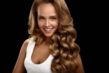 Güzel bir kadınla uzun parlak sarı dalgalı kıvırcık saçlı. Güzellik