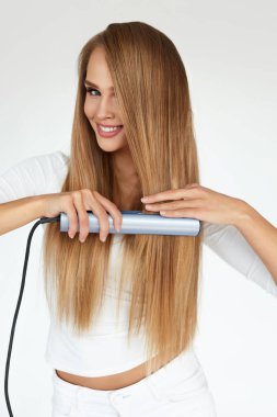 Güzel kadın uzun düz Saç Düzleştirici ile Ütü
