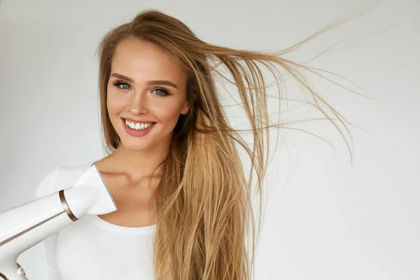 Hair Dryer. Kvinna torkning vacker blond långt rakt hår — Stockfoto