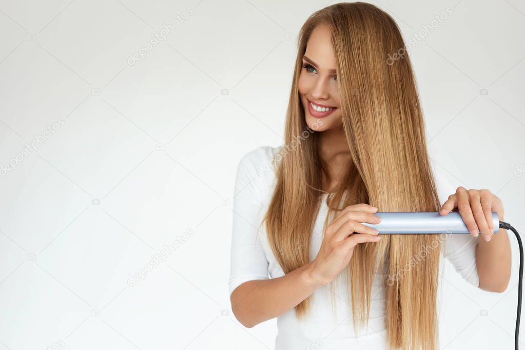 Beautiful Woman Ironing Long Straight Hair With Straightener