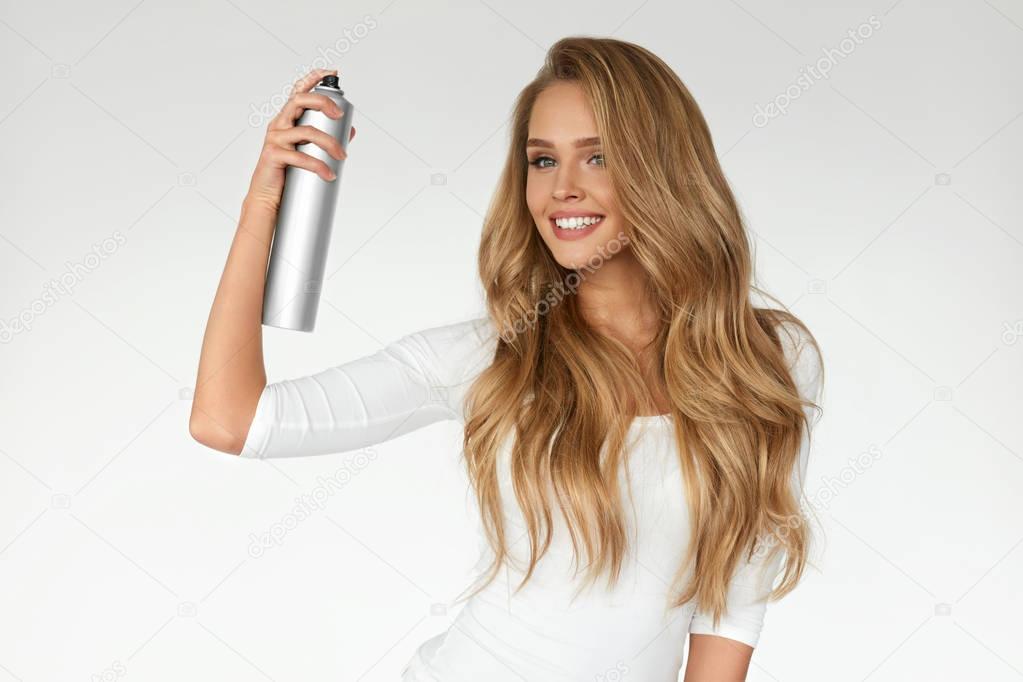 Woman Spraying Hairspray On Beautiful Curly Hair. Hairdressing