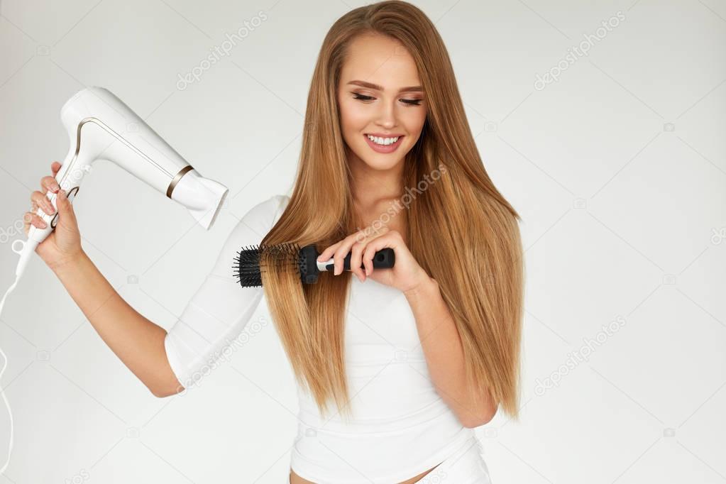 Hairdressing. Woman Drying Beautiful Healthy Long Straight Hair 