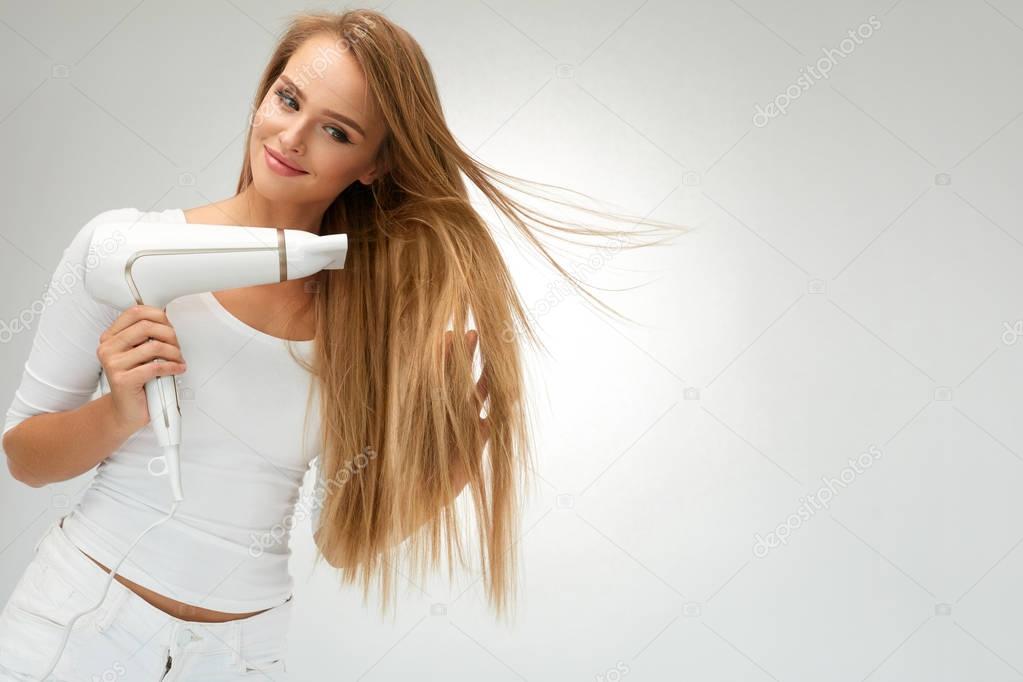 Beautiful Woman Drying Straight Hair Using Dryer. Hairdressing