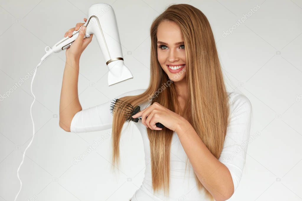 Hairdressing. Woman Drying Beautiful Healthy Long Straight Hair 