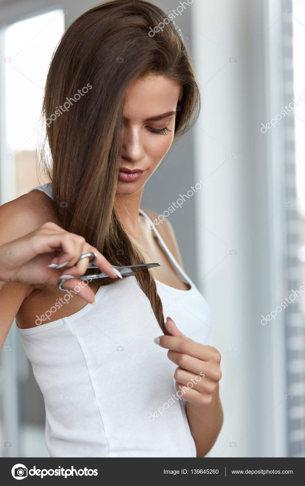 Beautiful Woman Cuts Split Ends Of Long Hair With Scissors