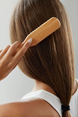 Fırça ile fırçalama sağlıklı uzun saçlı kadını arkadan görünüm