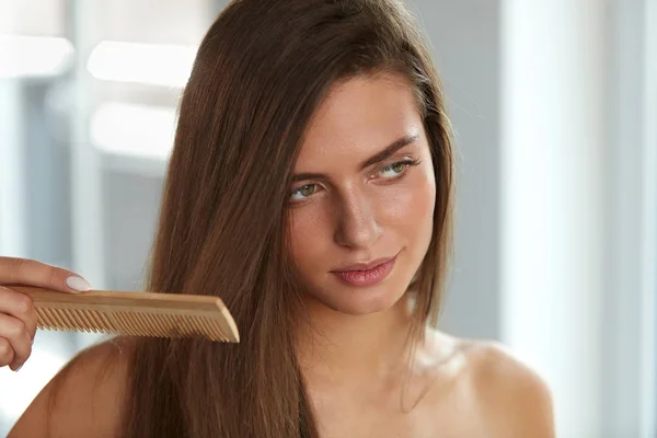 Mulher sexy com pente de cabelo na mão escovação. Saúde do cabelo — Fotografia de Stock