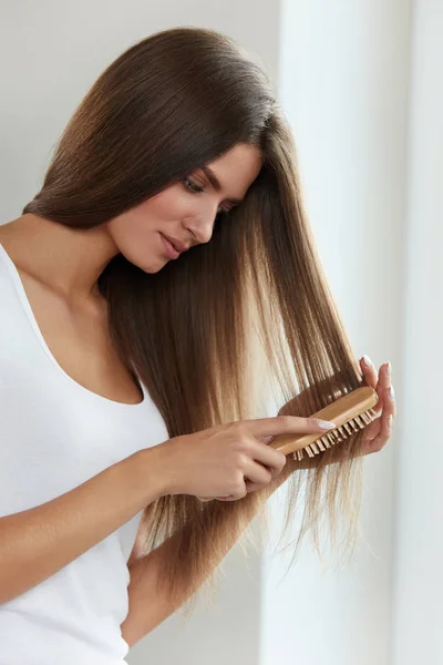 Soins capillaires. Belle brossage de cheveux féminins cheveux longs avec brosse — Photo