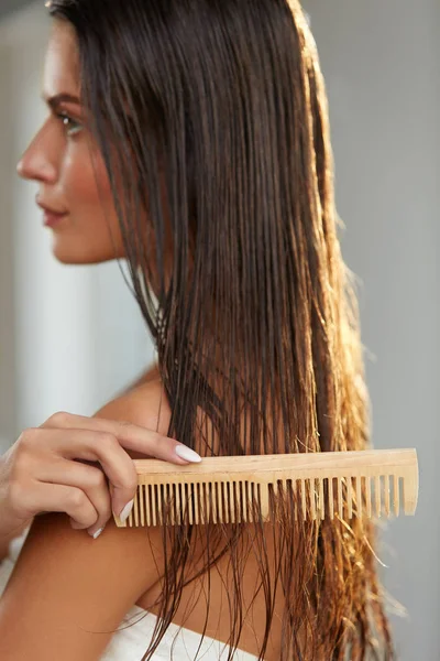 Vacker kvinna Hairbrushing hennes långa vått hår. Hårvård — Stockfoto