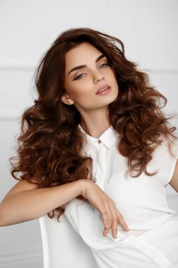 Dalgalı kıvırcık saç modeli ile güzel kız modeli. Kahverengi saç rengi