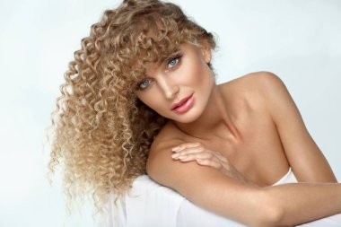 Güzel bir kadın modeli sarışın kıvırcık saçlı ve yumuşak deri